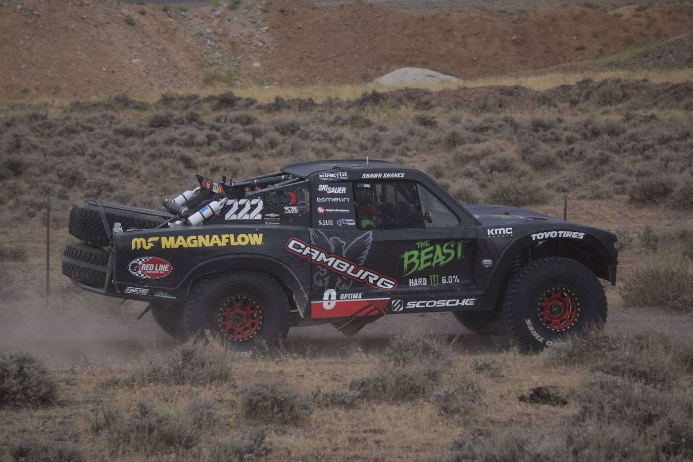 The Beast, a black race truck running through sagebrush